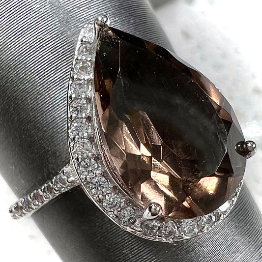 A pear shape smoky quartz set in a sterling silver and CZ halo ring.