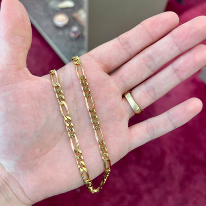 A 14k yellow gold men's figaro chain.