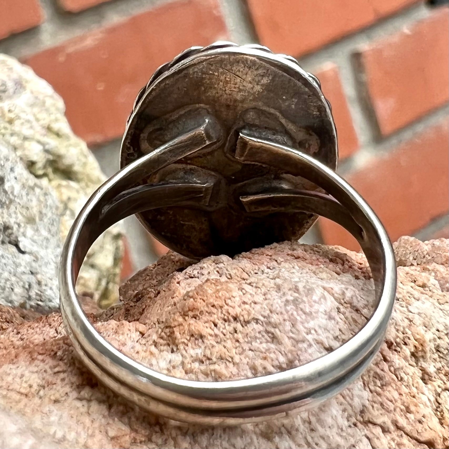 A men's sterling silver rope bezel ring set with a red tiger's eye stone.