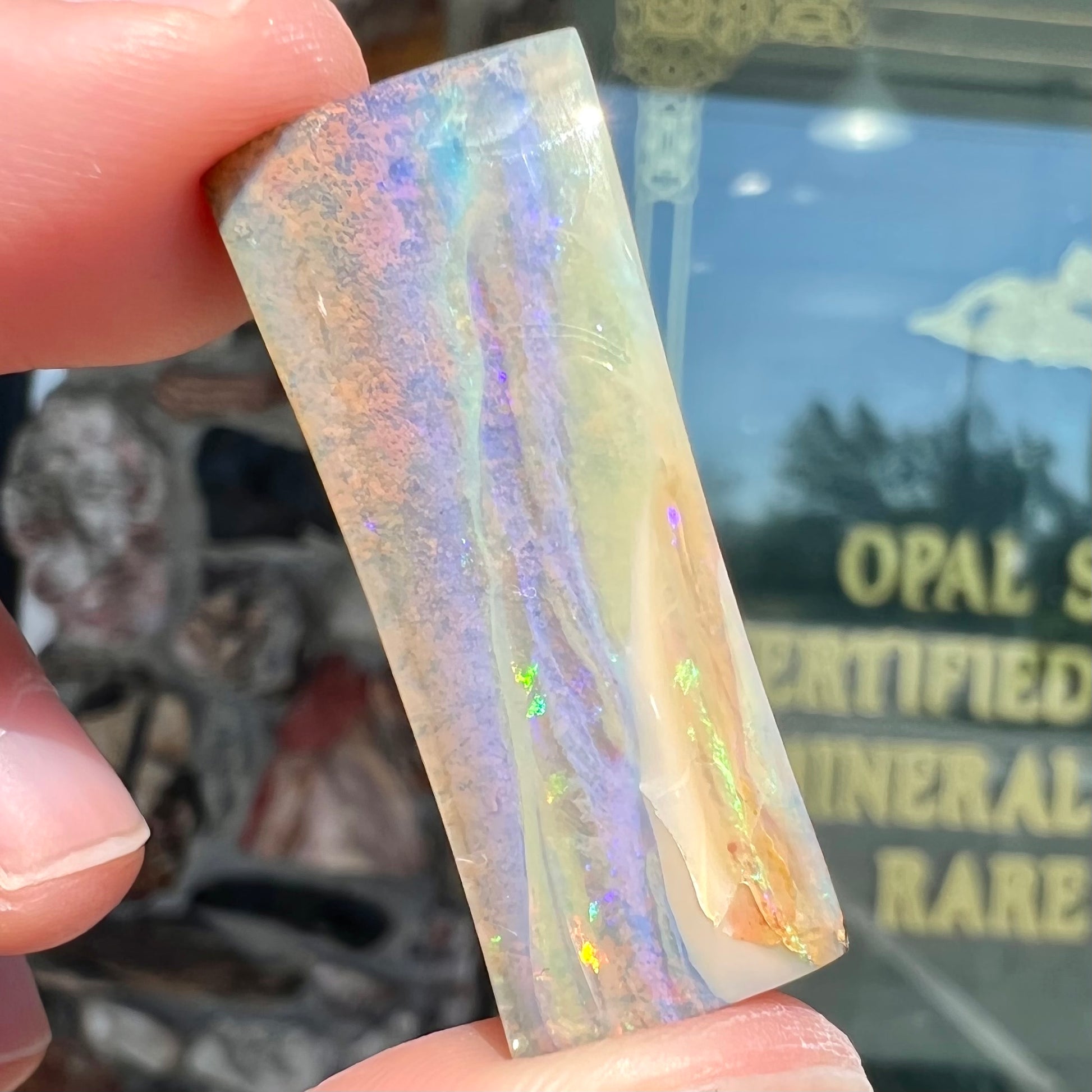 A polished, tapered rectangular cut boulder opal stone from Quilpie, Australia.