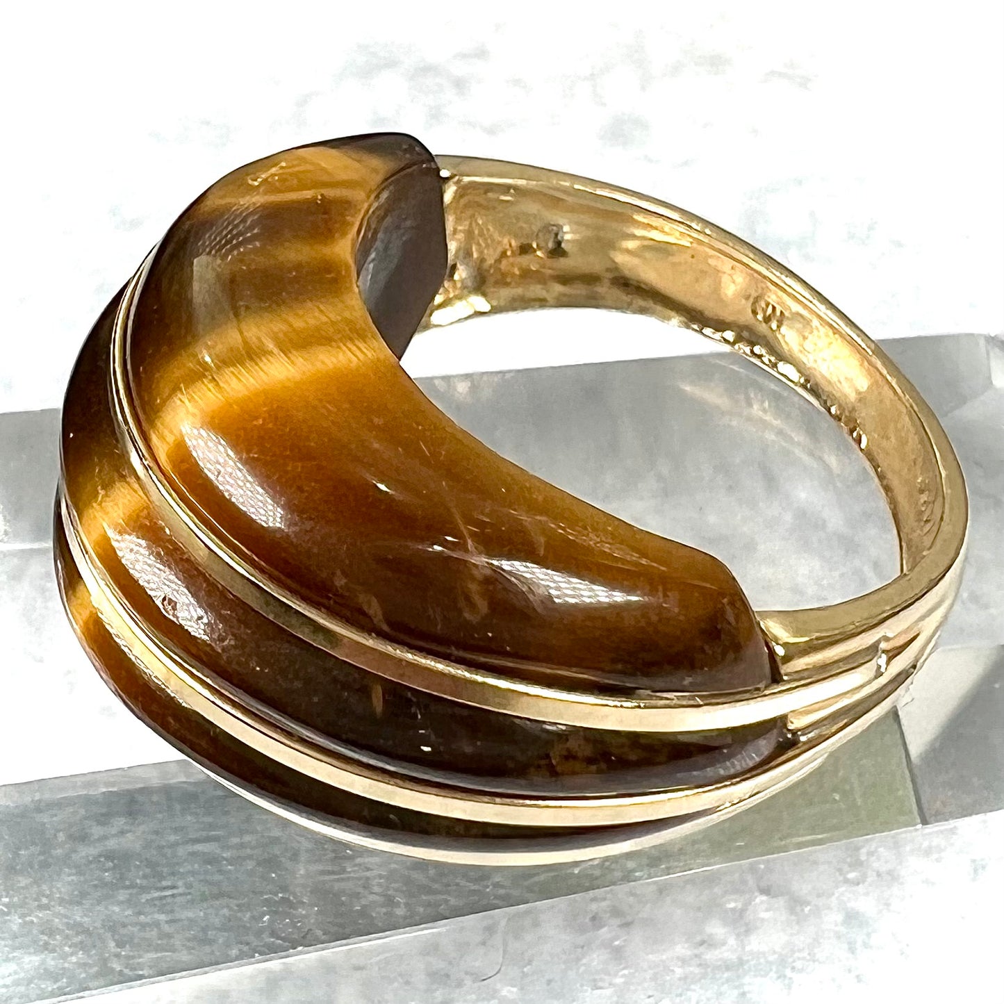 A ladies' high dome carved tiger's eye ring cast in yellow gold.