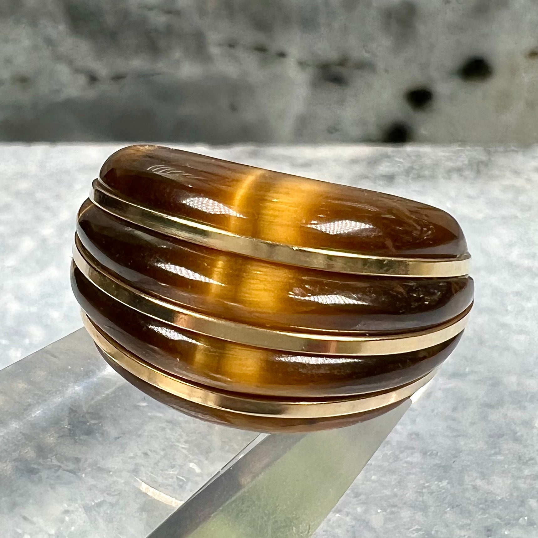 A ladies' high dome carved tiger's eye ring cast in yellow gold.