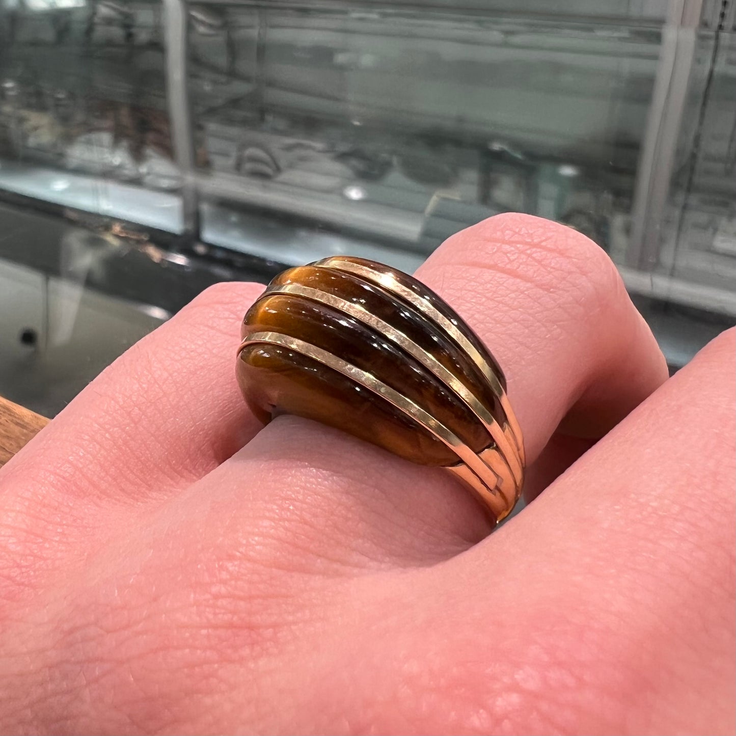 A ladies' high dome carved tiger's eye ring cast in yellow gold.