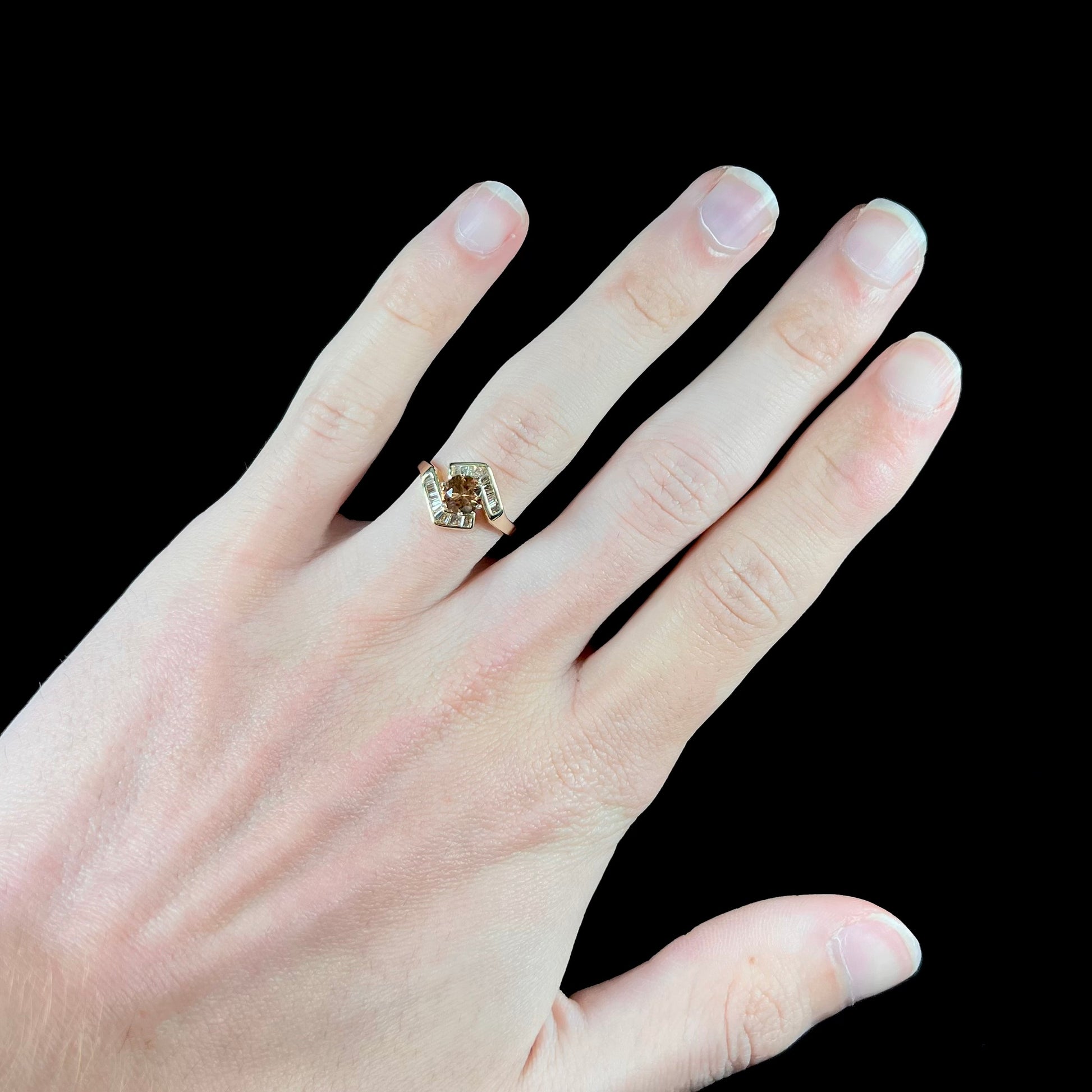 A yellow gold ladies' golden topaz ring set with baguette cut side diamonds.