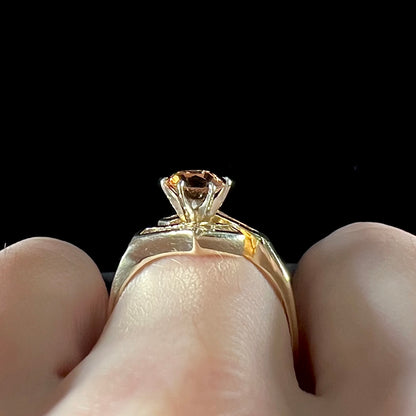 A yellow gold ladies' golden topaz ring set with baguette cut side diamonds.