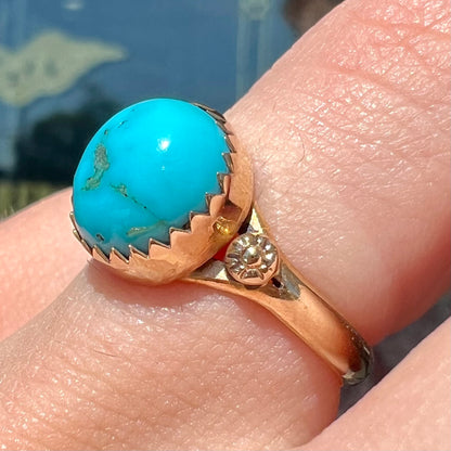 A ladies' yellow gold turquoise ring.  The turquoise is a round cabochon cut.