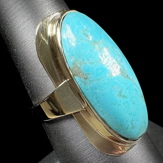 A Sleeping Beauty turquoise solitaire ring cast in 14kt yellow gold.