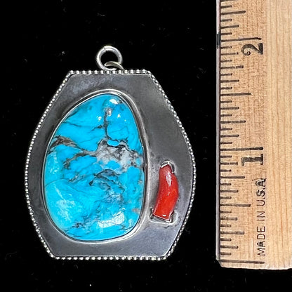 A sterling silver turquoise and polished coral branch pendant.  The back of the piece is signed "A.H."