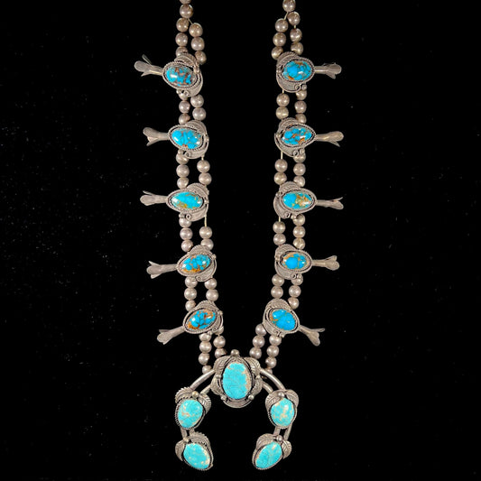 A silver Navajo men's squash blossom necklace set with Fox turquoise and Sonora turquoise.