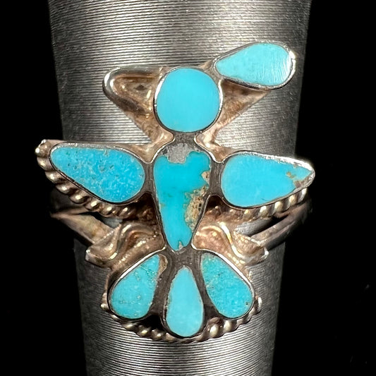 A sterling silver and turquoise inlay ring.  The ring is in the shape of a Native American thunderbird.