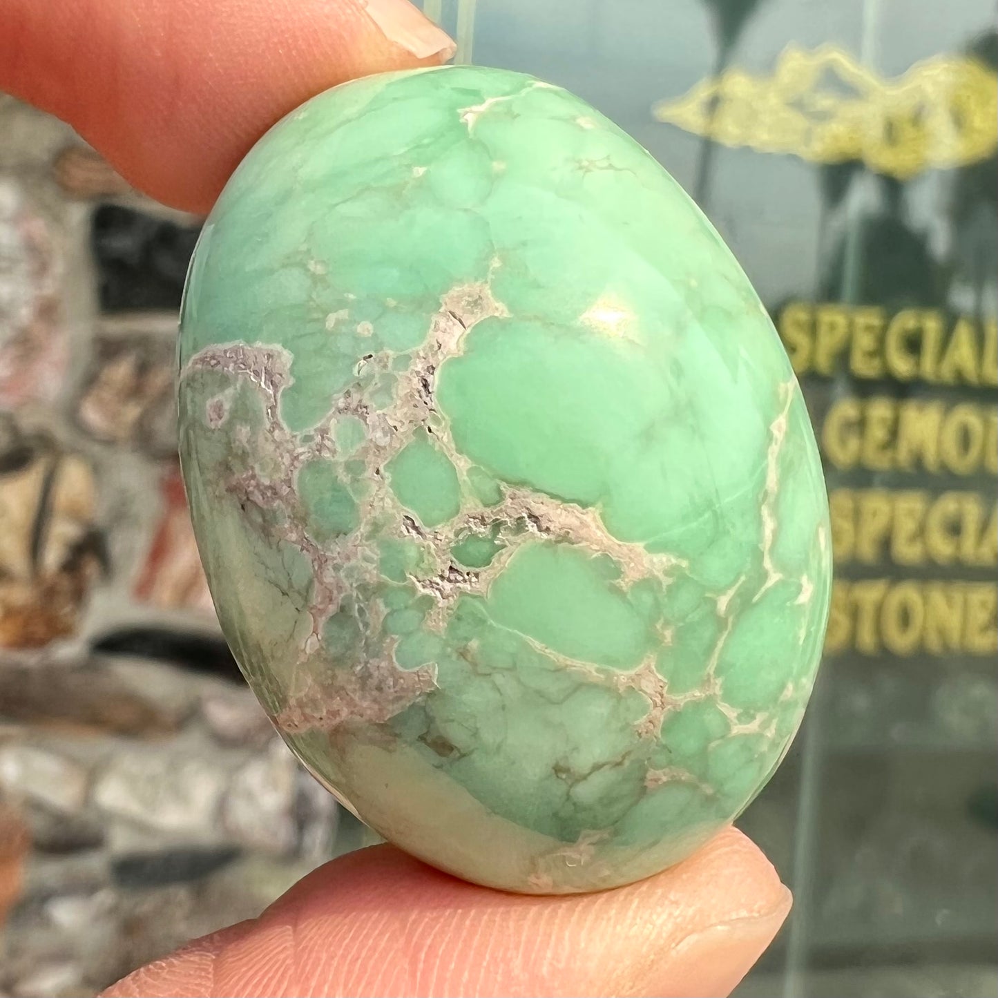 A loose, oval cabochon cut green variscite stone from Utah, USA.