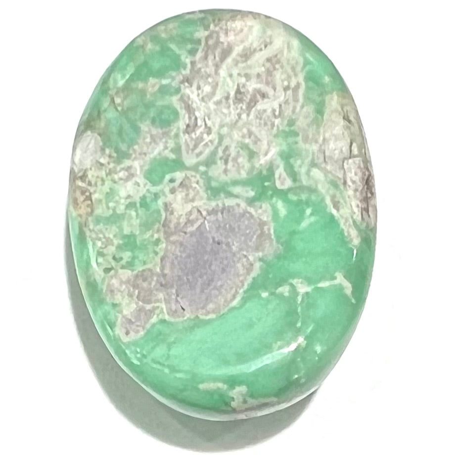 A loose, oval cabochon cut green variscite stone from Utah, USA.