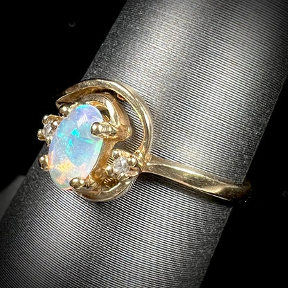 A dainty ladies' yellow gold opal and diamond accent ring.