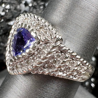 A white gold trillion cut tanzanite ring set with a diamond halo and diamond accents.