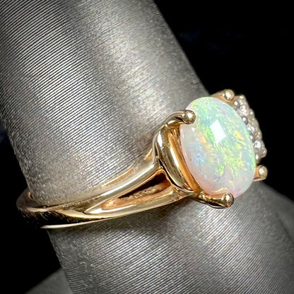 A ladies' yellow gold Coober Pedy, Australian opal ring set with three round cut diamonds.