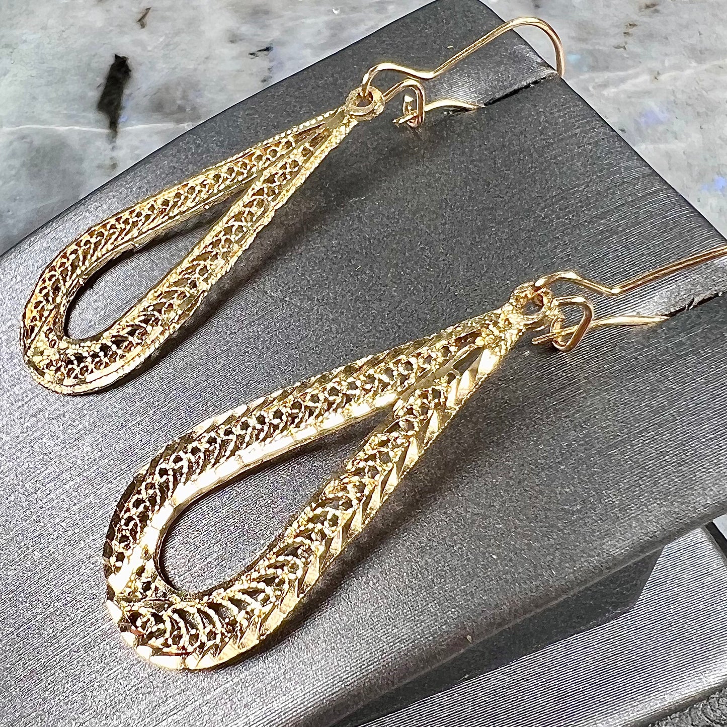 A pair of pear shape yellow gold filigree dangle earrings.